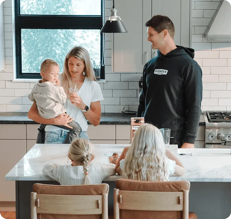 Family of five in a modern kitchen drinking milk