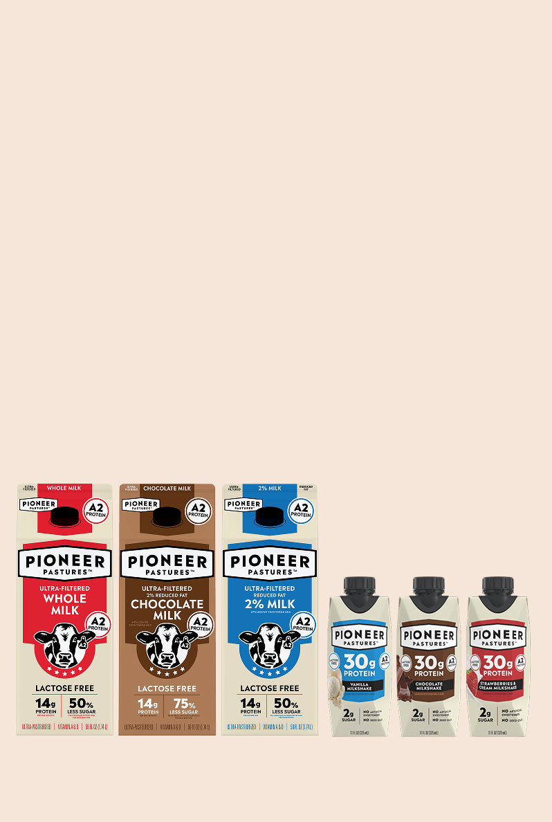 Lineup of Pioneer Pastures A2 ultra-filtered dairy products including whole milk, chocolate milk, and protein shakes in vanilla, chocolate, and strawberry flavors