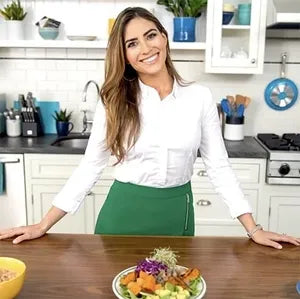 Ilana Muhlstein standing in a kitchen with a salad on a counter